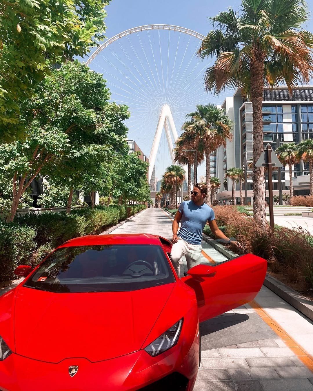 Chris stepping out of a red supercar in Dubai